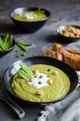 Creamy green pea soup with sour cream
