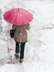 Blurry woman under the umbrella during snowfall
