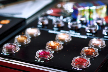 Set of decorative cosmetics. Various makeup products. A lot of professional cosmetics for make up. Professional multicolor eyeshadow palette and red lipsticks. Colorful bright eye shadows set backdrop