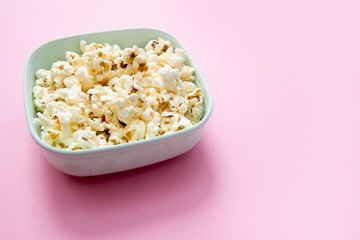 Popcorn bowl viewed from above on pink background. Flat lay. Top view