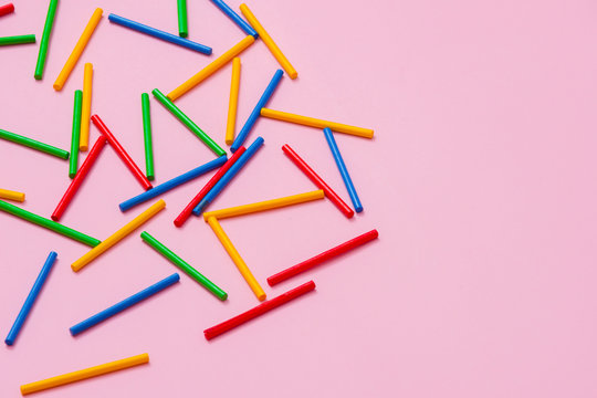 Colorful wooden sticks against pink background