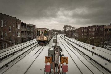 Subway train approaching stop with snow covered tracks on extremely cold day