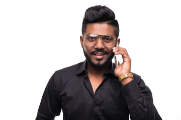 Fototapeta premium Young indian hipster man talking on mobile phone isolated against white background