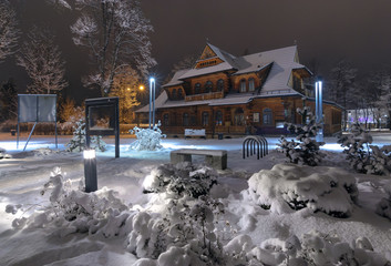 Snow-covered traditional house in Zakopane, in snow evening
