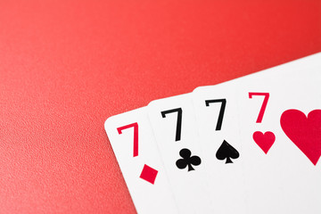 four seven playing cards on a red background