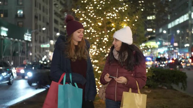 Two girls shop Christmas presents in New York