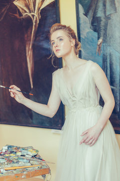 Young intersting girl painter drawing her art creation. Fine art, elegant, inspiration concept