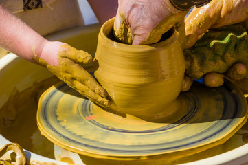 hands of the skilled master Potter and children's hands, training of the kid to production of pottery on a Potter's wheel