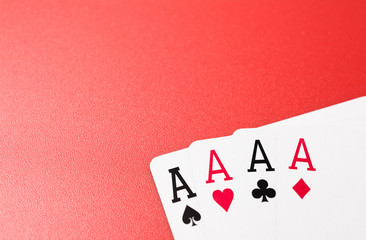 four ace playing cards on red background