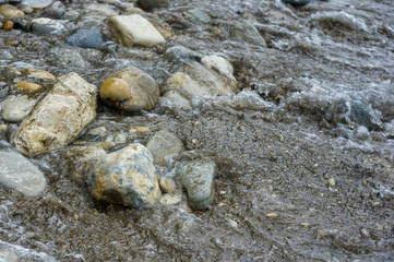 pebble stones on the sea beach, the rolling waves of the sea with foam