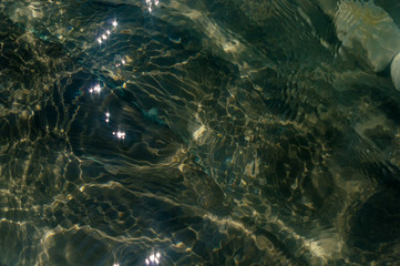 pebble stones on the sea beach, the rolling waves of the sea with foam