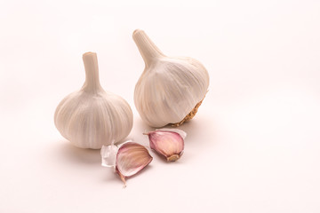 A head of fresh garlic with cloves isolated on a white background. The most popular addition to dishes. An aromatic ingredient of meals. Natural healing properties.