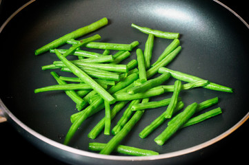 Green beans ready for cooking in frying pan. Close up view of green beans on a frying pan