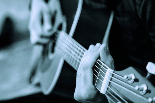 Close up man playing the guitar outdoors. Music, art, business concept.