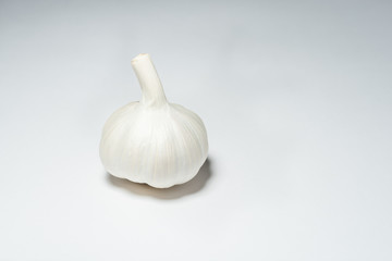 A head of fresh raw garlic isolated on a white background. The most popular addition to dishes. An...