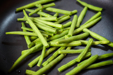 Green beans ready for cooking in frying pan. Close up view of green beans on a frying pan