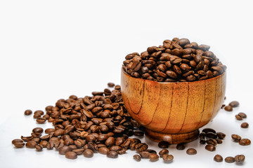 Coffee beans. Roasted coffee beans in bamboo bowl, isolated on white background.