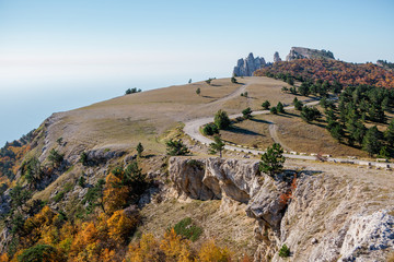 Image of picturesque mountain area, trees, hills, blue sky, road