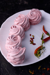 Spicy dessert with red pepper. Marshmallow Delicious and appetizing marshmallow with taste of red pepper on a black background.