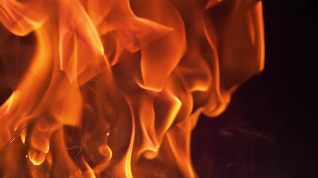 SLOW MOTION, MACRO, DOF: Cinematic shot of a flaming blade being lifted out of the hot oil by the blacksmith forging traditional knives. Smoke coming off the oil surface as knife blade is being cooled