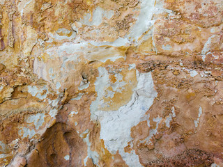 Natural stone texture of limestone . Yellow and red colorful background, flaky limestone rocky texture closeup