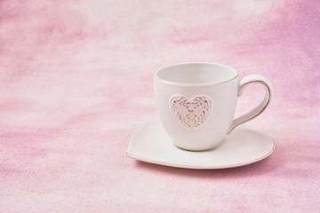 Mug with heart ornament on pink background. Copy space