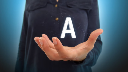 Businesswoman on blurred background holding hand letter A