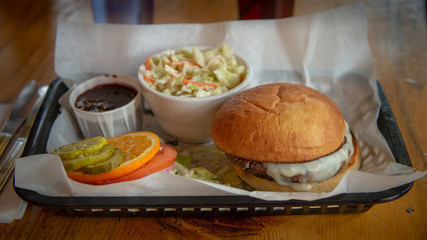 Cheeseburger and coleslaw on a tray in a restaurant setting