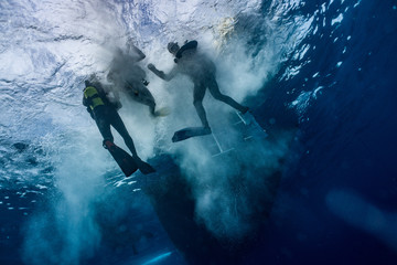 Divers jumping into water 