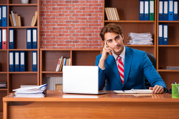 Young handsome employee sitting in the office  