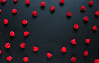 Round Frame of red raspberry berries on black background
