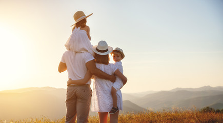 Happy family: mother, father, children son and daughter on sunset