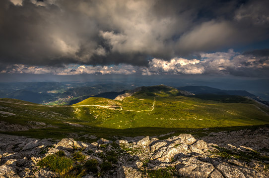 Rocky path and grassy rax plateau on hike Dambocksteig from Schneeberg, highest peak Kosterwappen, along Waxriegel to Puchberg in the cloudy sunset, Raxalpe, Lower Austria