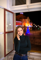 Young woman holding phone smiling and looking at camera