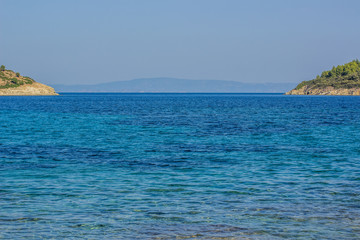 Naklejka premium idyllic symmetry scenic landscape of two islands coasts background and vivid blue water surface of Indian ocean bay foreground, empty copy space for your text or inscription 