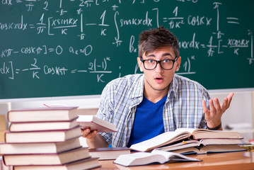 Young male student studying math at school