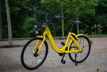 Fototapeta na wymiar Yellow Bicycle on City Sidewalk