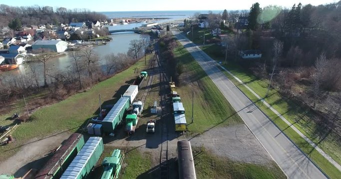 Flying Over Trains Caboose On Railway Tracks And White Truck In Boating Marina Port 4K Aerial View