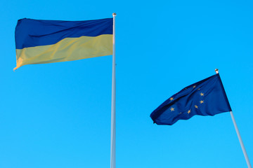Flag of the European Union and Ukraine against the sky.