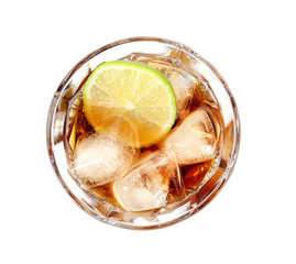Glass of cocktail with cola, ice and cut lime on white background, top view