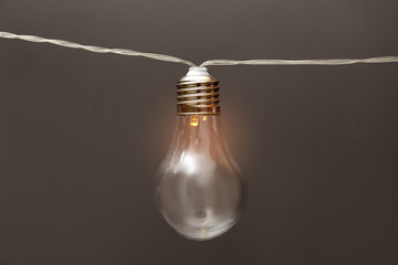 Lamp with light bulb on grey background