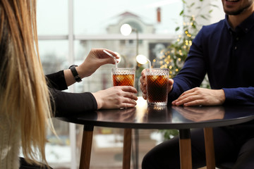 Couple with glasses of cold cola at table in cafe, closeup - obrazy, fototapety, plakaty