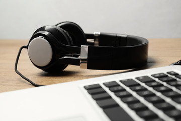 Obraz na płótnie Canvas Stylish headphones and laptop on table. Modern technology