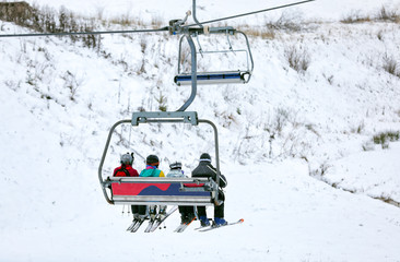 Chairlift with people at ski resort. Winter vacation