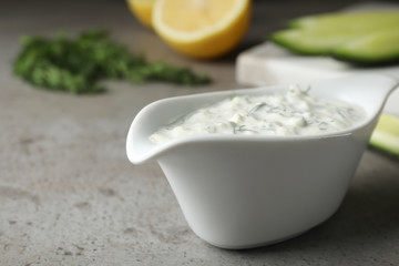 Ceramic dish of Tzatziki cucumber sauce on table. Space for text