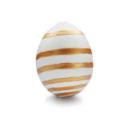 Traditional Easter egg decorated with golden paint on white background