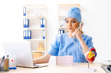 Young female doctor cardiologist sitting at the hospital 