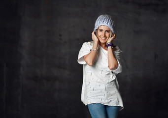 Blonde woman in light blue knitted hat and jeans happy smiling sitting posing