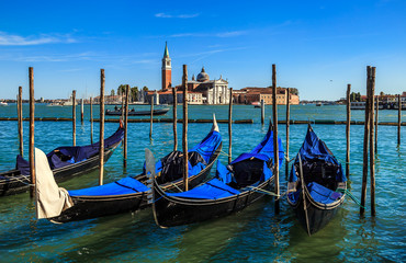 Gondolas on the background of San Giorgio Maggiore island and Cathedral of the same name. View from the waterfront near Saint Mark's square. Venice, Italy.