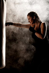 Obraz na płótnie Canvas kick fighter girl punching a boxing bag